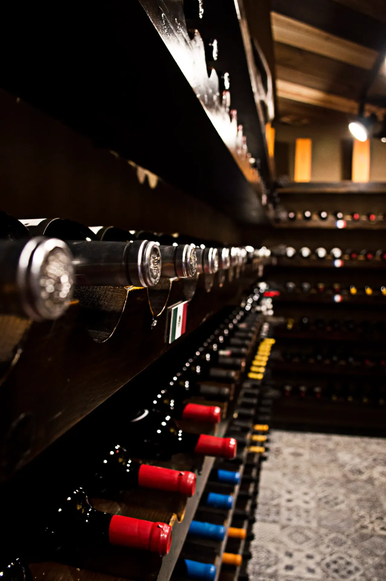 Dramatic perspective of the wine cellar lined with hundreds of bottles, reflecting the restaurant's serious commitment to fine wine pairing.