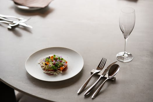 Elegant gedeckter Tisch in einem feinen Zürcher Restaurant mit perfekt präsentiertem Gourmet-Gericht und Wein vor urbaner Kulisse