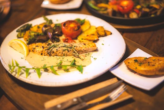 Eine cremige Pasta mit geröstetem Rosenkohl und Zitronenzesten, serviert in einer Schüssel auf einem Holztisch, umgeben von frischen Zutaten wie Zitronen und Kräutern.