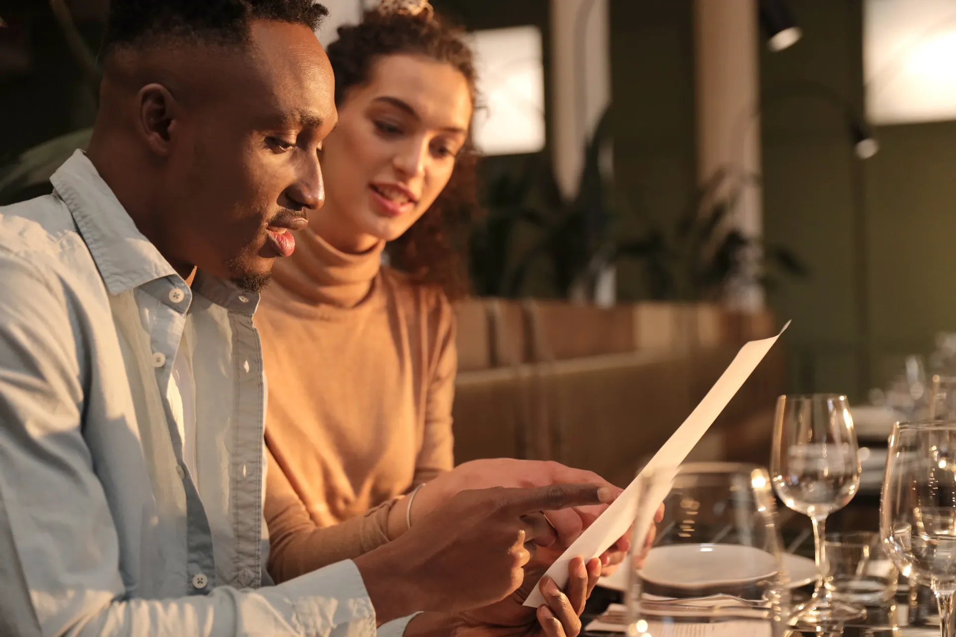 A couple reviews the menu together at an elegantly set table, capturing the intimate dining experience Casa Helvetia offers.