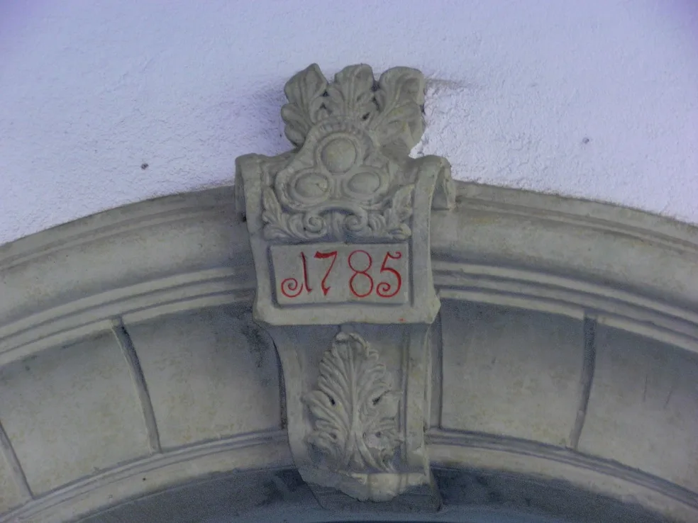 Close-up of the 1785 keystone above the Alte Mühle entrance, showing the historic ornamental stonework that anchors the building's identity.