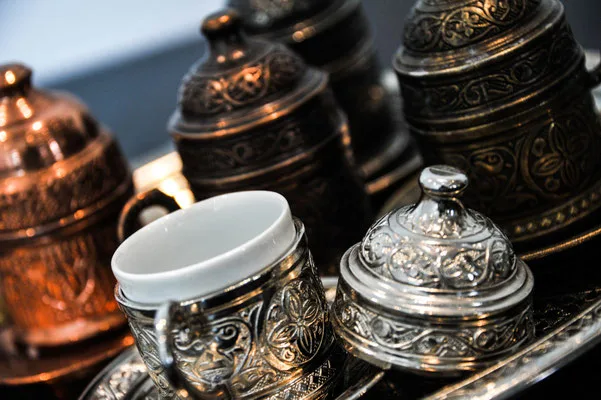 Ornate Turkish copper and silver coffee cups with intricate engraved metalwork.