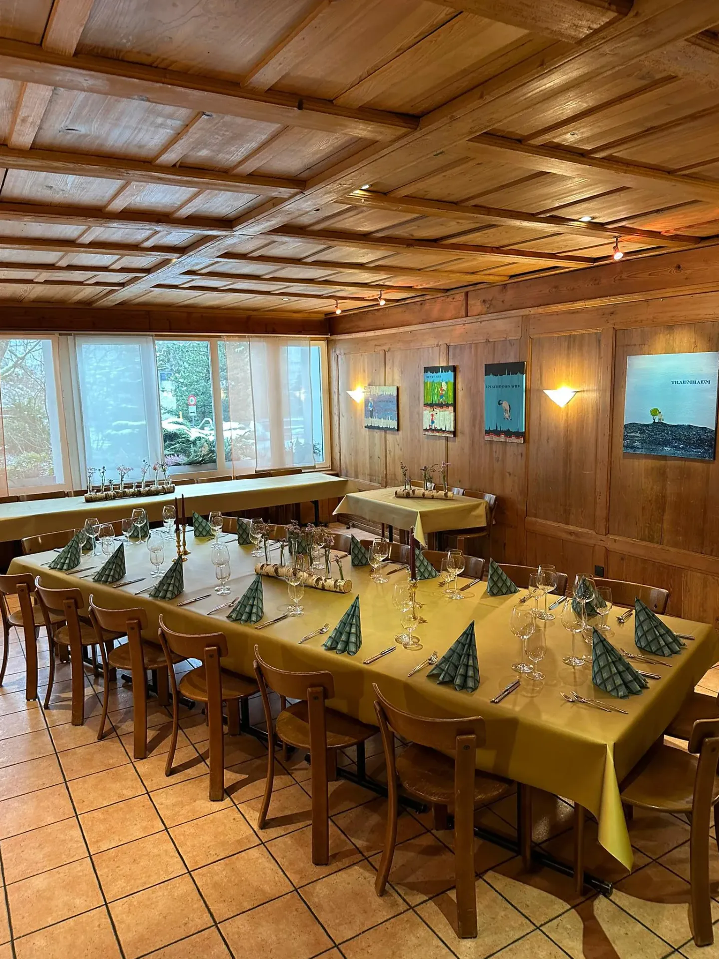 Bright dining room set with mustard tablecloths and green napkins for a group event.