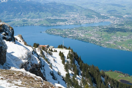 Elegante Rooftop-Bar mit Panoramablick über eine Schweizer Stadt bei Sonnenuntergang, wo Gäste an modernen Tischen sitzen und Cocktails genießen.